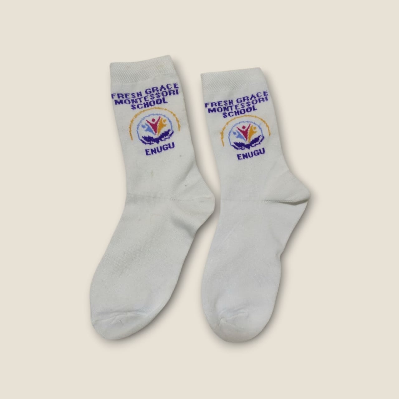 White school socks with Fresh Grace Montessori School Enugu name and crest knitted in blue and gold