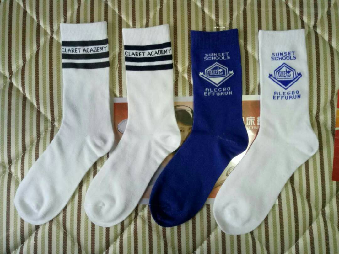 White socks with Claret Academy twin stripes beside blue and white Sunset Schools socks with a knitted crest