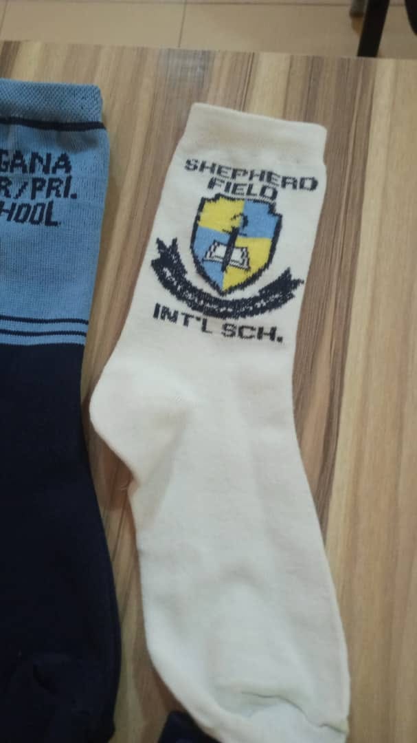 Cream school sock with Shepherd Field International School blue and yellow shield crest